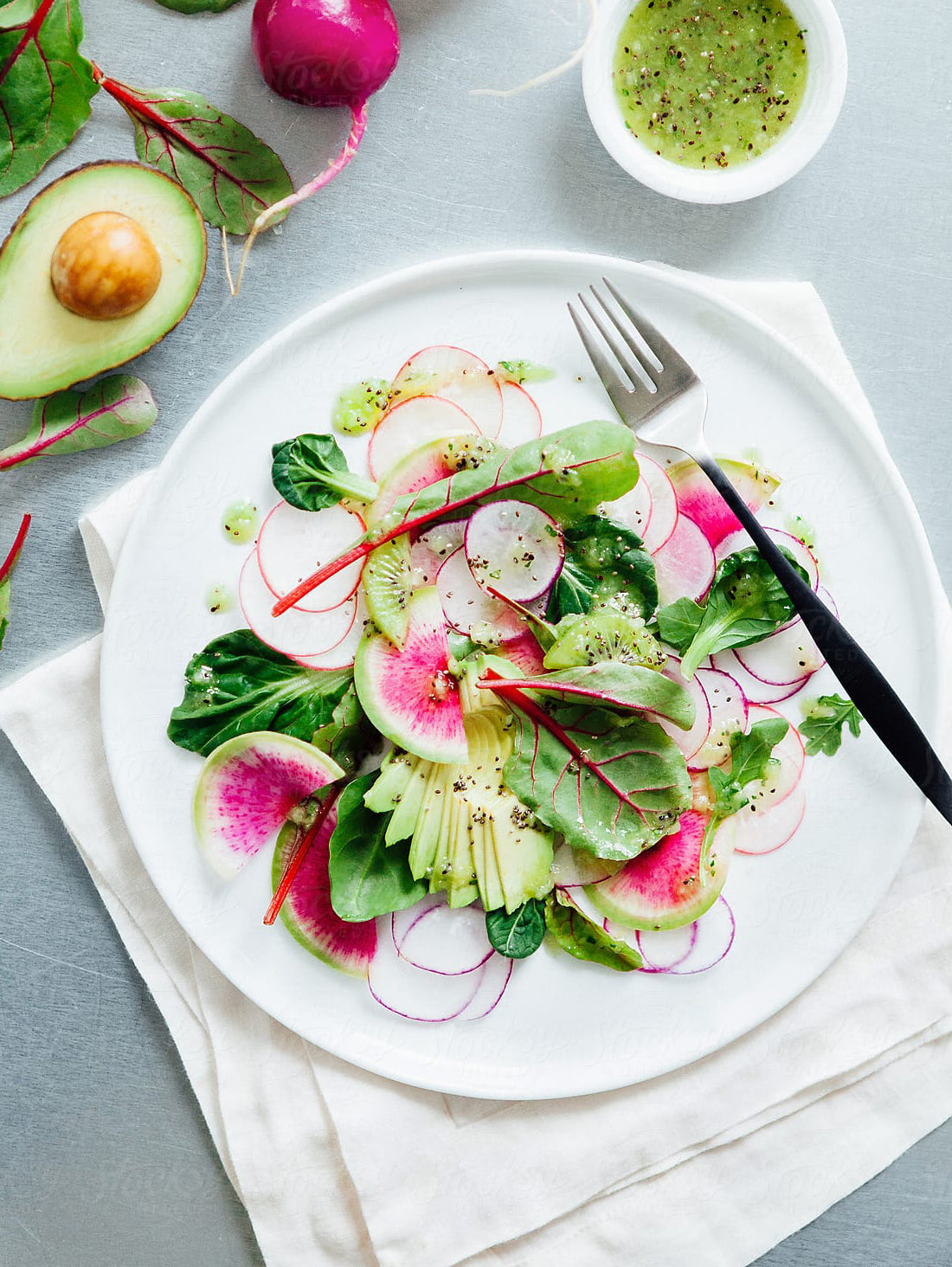 salad on white plate and napkin with a fork