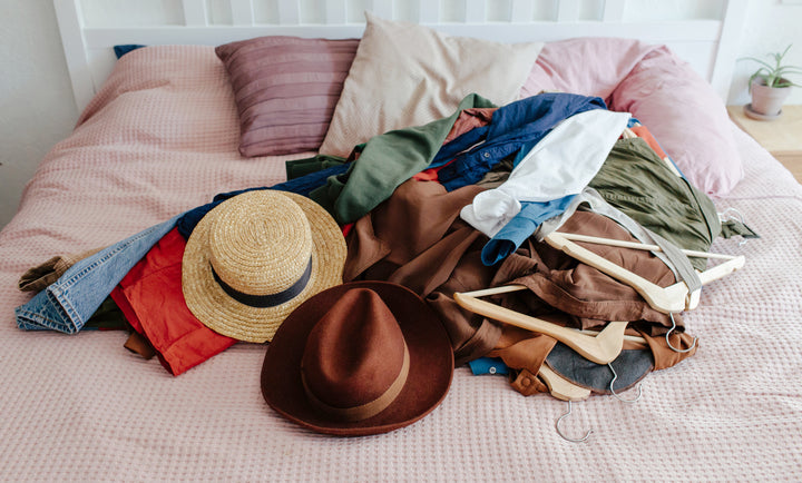 Clutter of clothes and accessories on bed