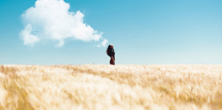 Woman in field breathing in air