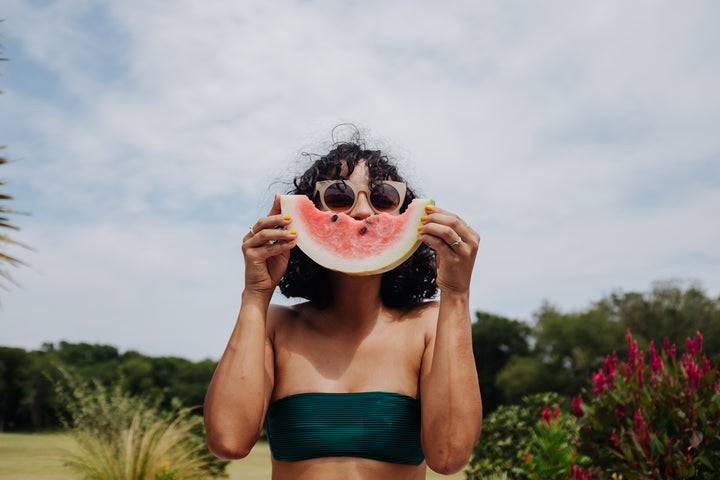 Woman Holding Watermelon In Front of Face Outside