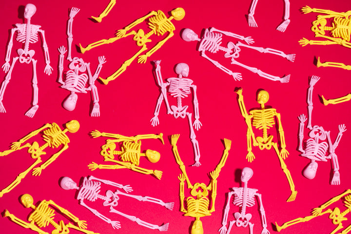 Pink and yellow skeletons on red background