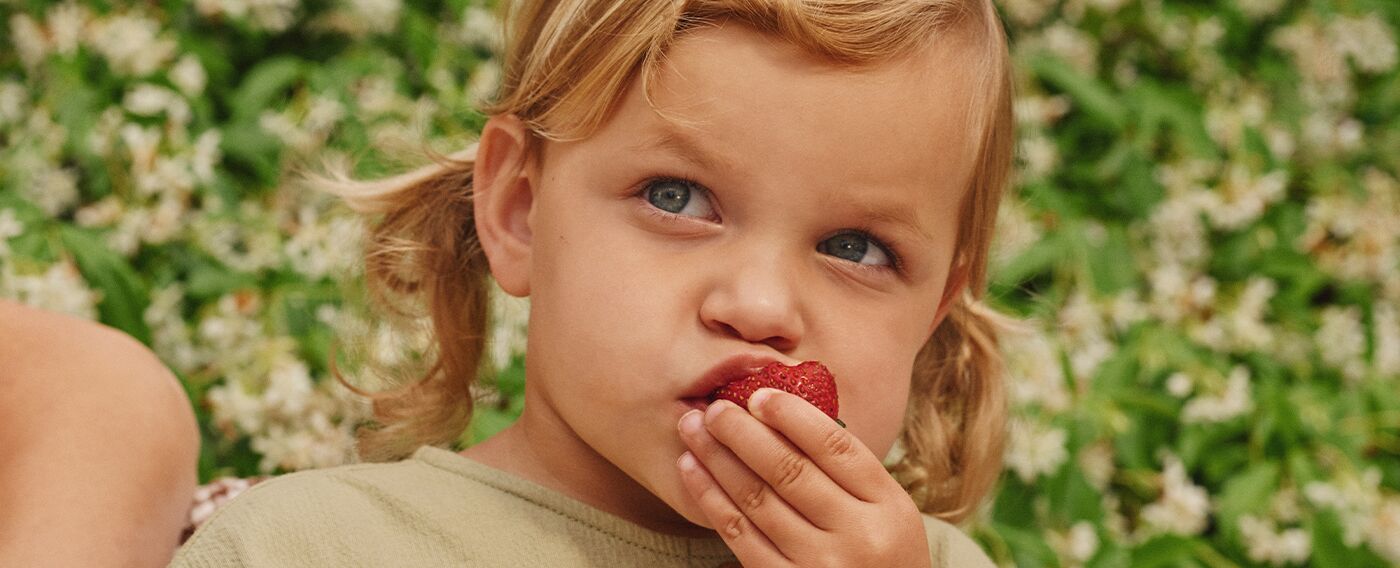child eating a strawberry