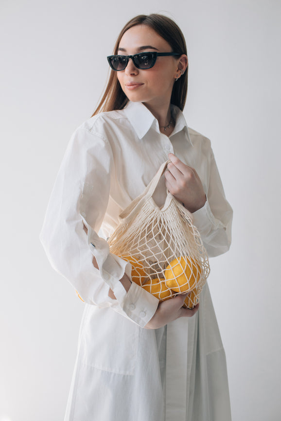 girl in white dress holding reusable bag