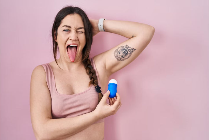 Girl Holding Deodorant up with Pink Background and Silly Facial Expression