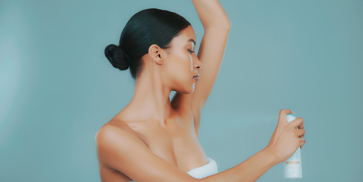 Girl putting on spray deodorant