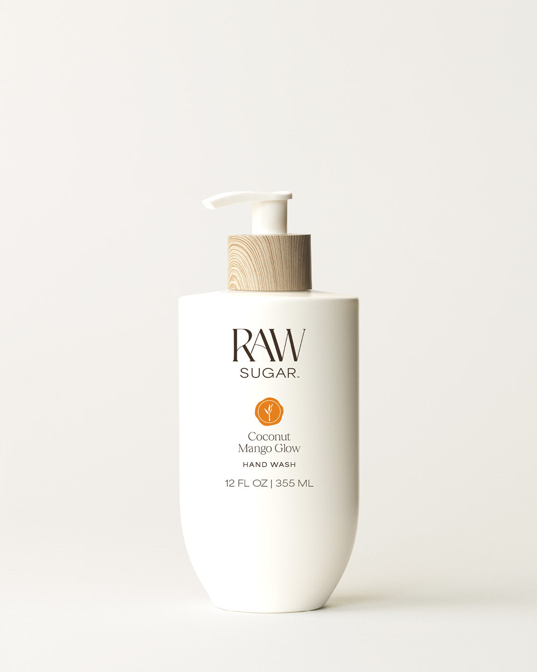 Bottle of Raw Sugar Mango Hand Wash on a cream background, designed to help gently cleanse hands with clean ingredients.