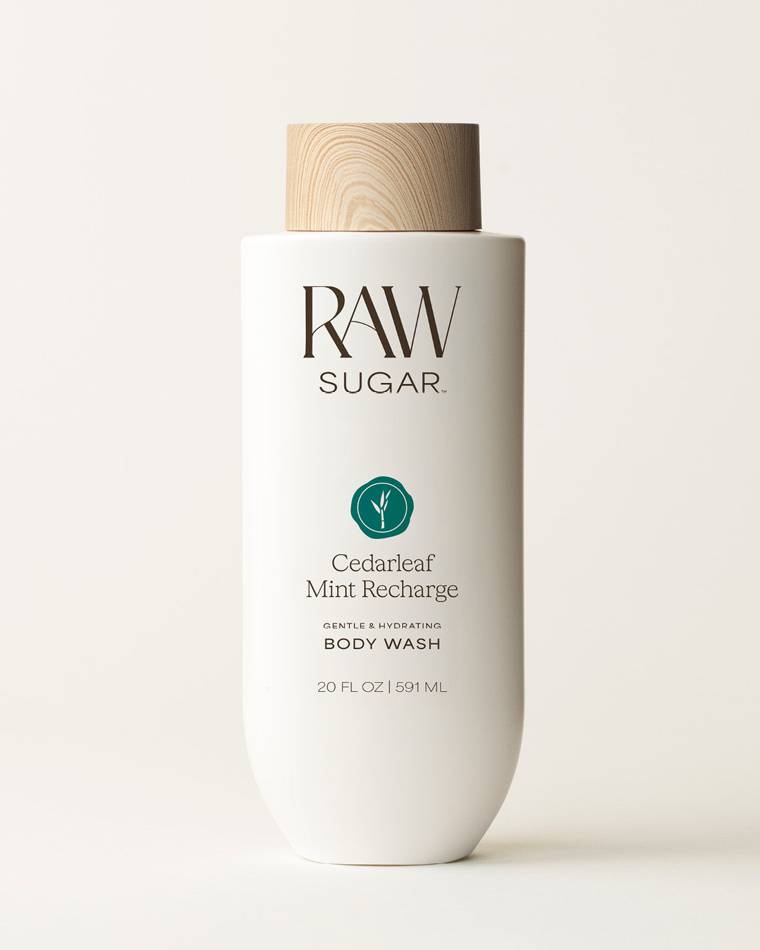 Bottle of Raw Sugar Cedar + Mint Body Wash on a cream background, designed to help gently cleanse and hydrate skin with clean ingredients.