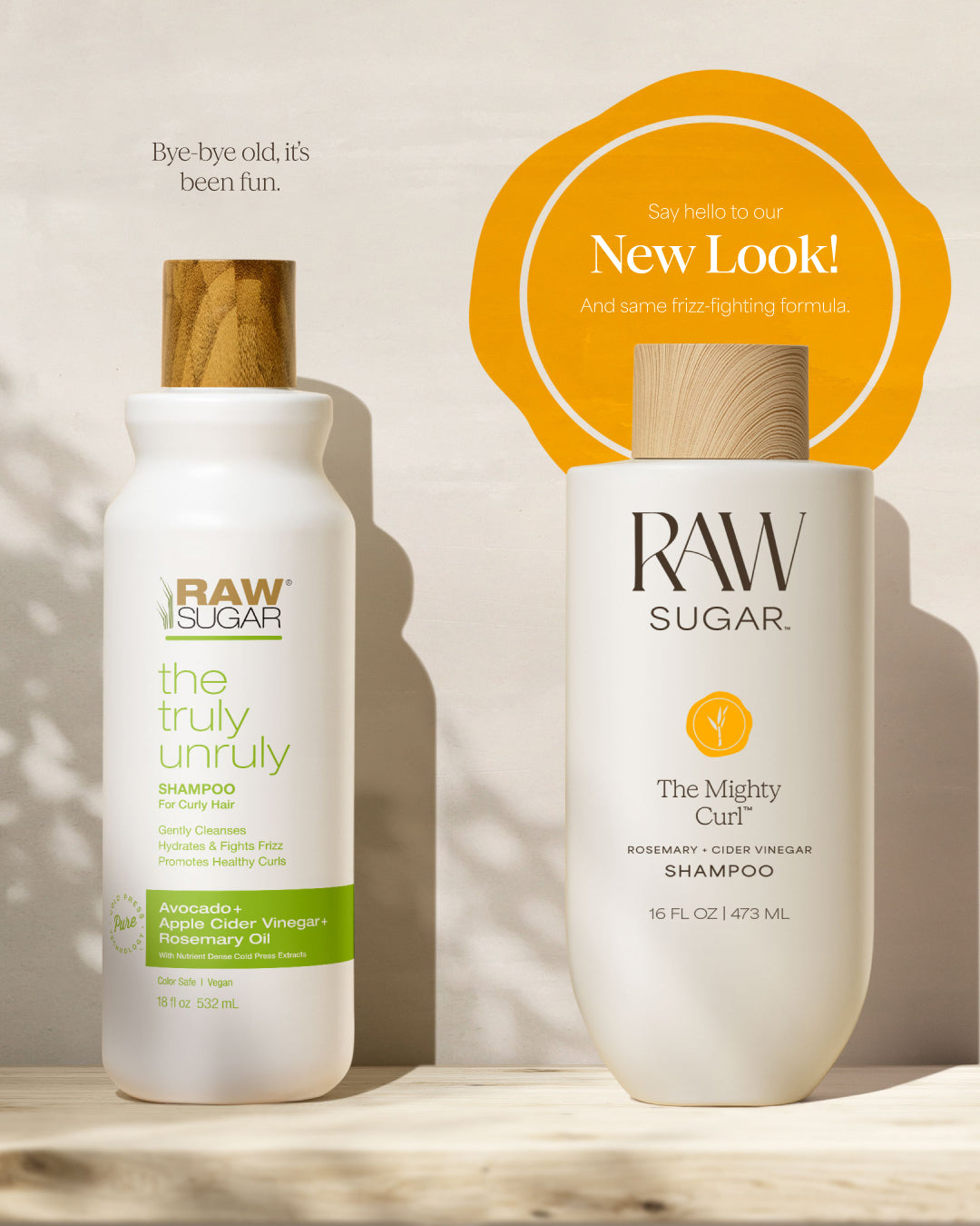 Two bottles of Raw Sugar hair care products on a wooden surface with a neutral background, designed to help cleanse curly hair with clean ingredients.