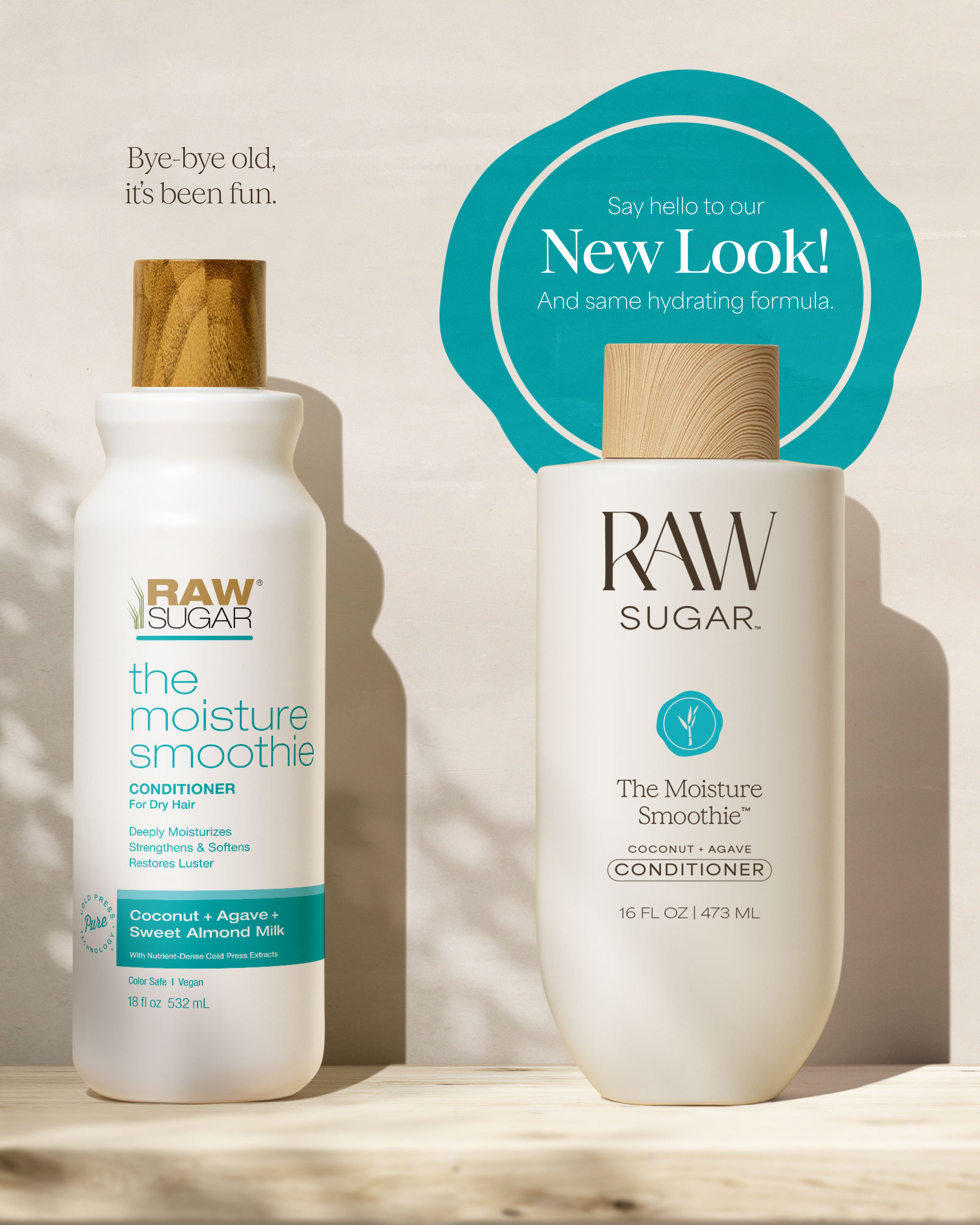 Two bottles of Raw Sugar 'The Moisture Smoothie' conditioner on a wooden surface with a beige background.