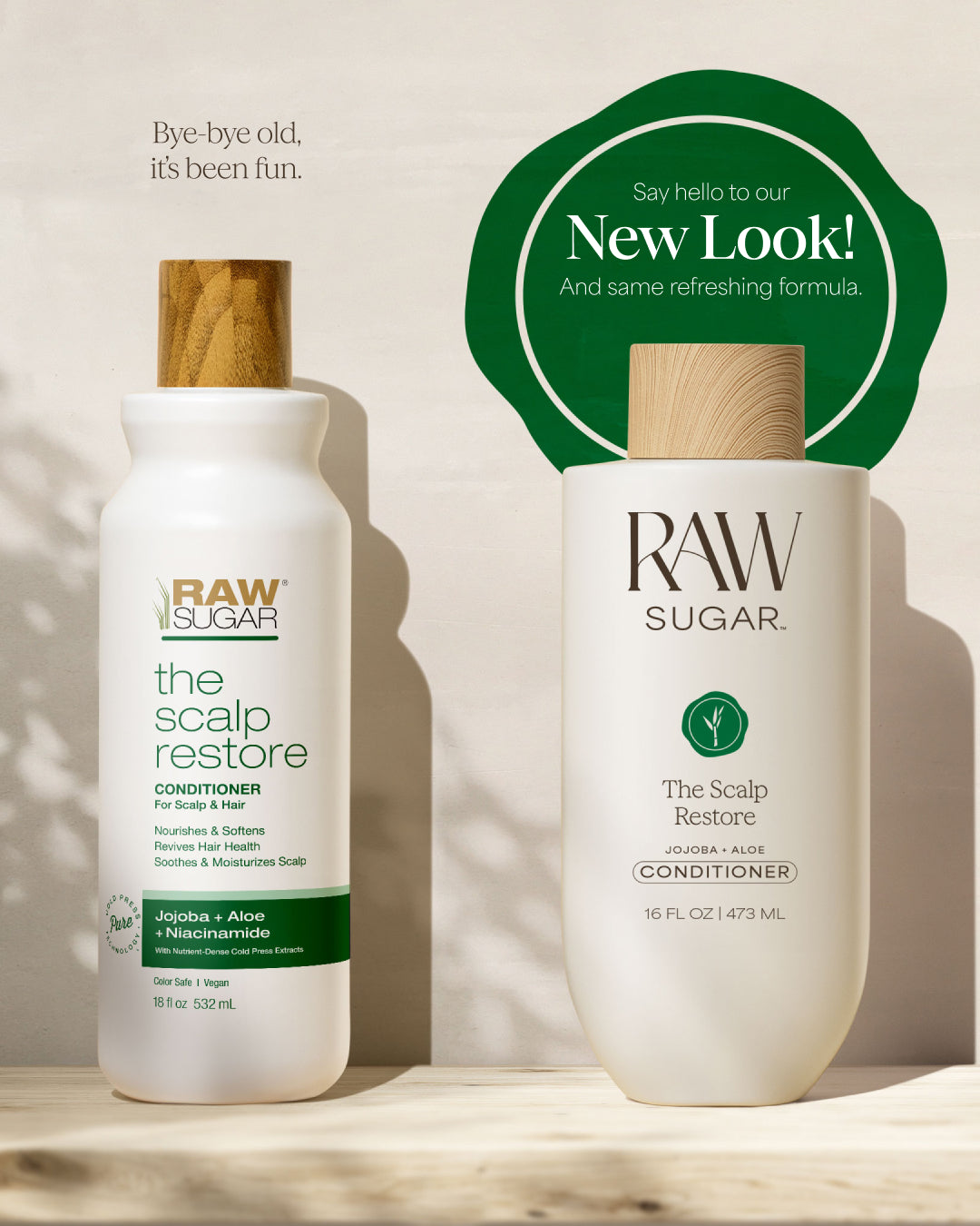 Two bottles of Raw Sugar hair care products on a wooden surface with a green label indicating a new look.