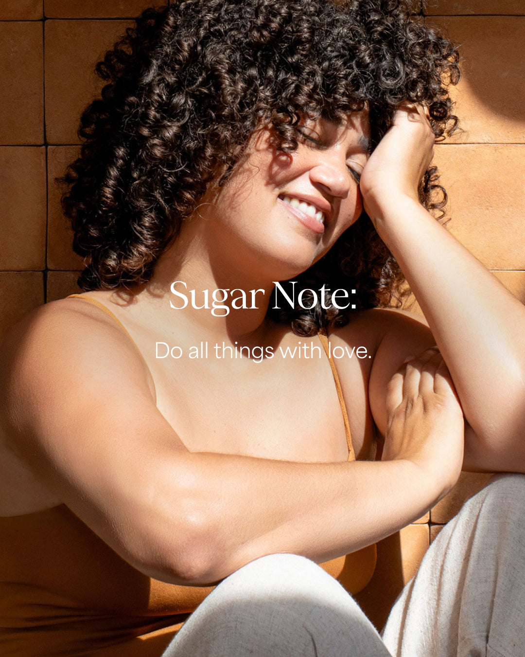 Woman with curly hair sitting against a wooden wall with 'Sugar Note' text overlay.