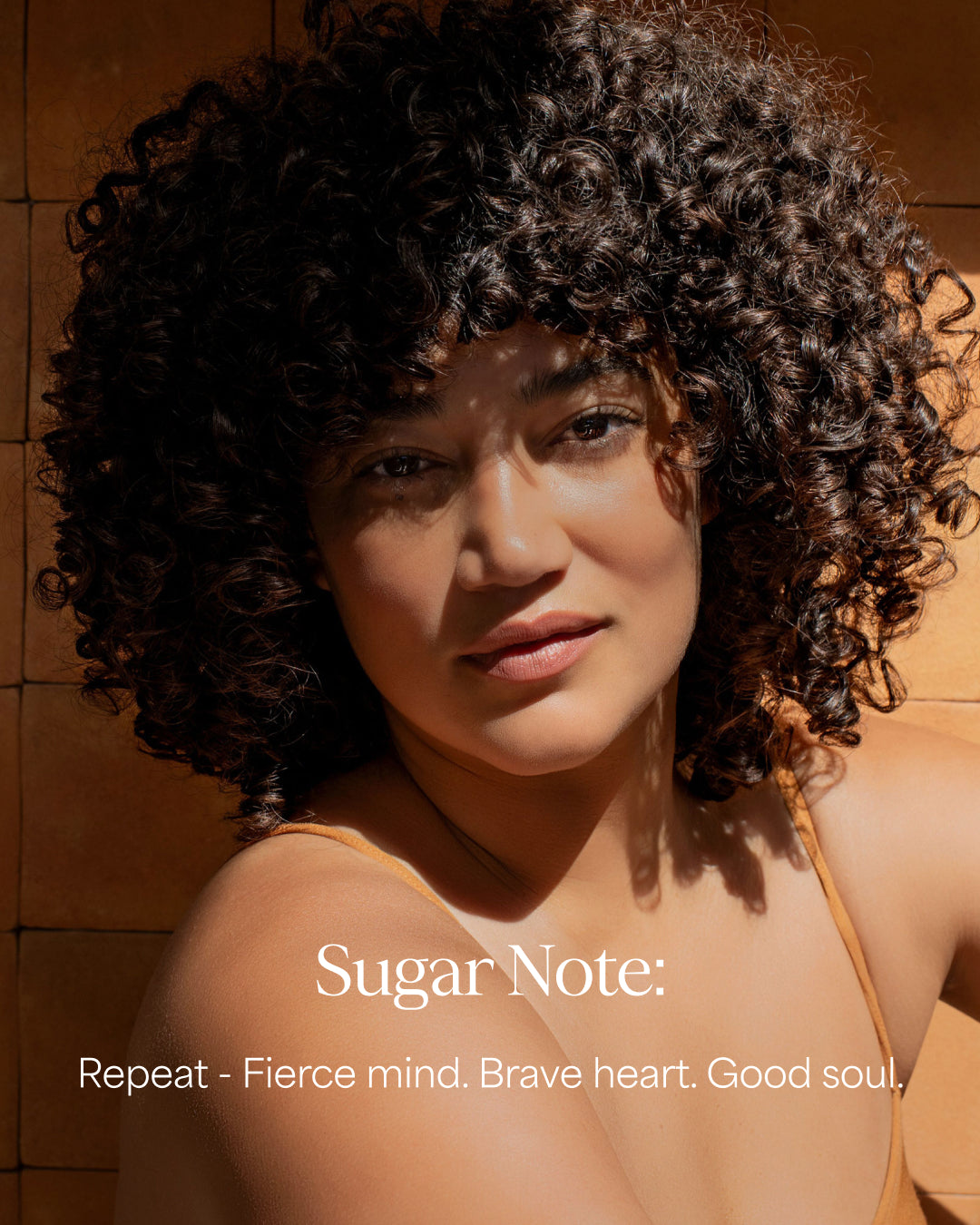Woman with curly hair against a wooden background with 'Sugar Note' branding.
