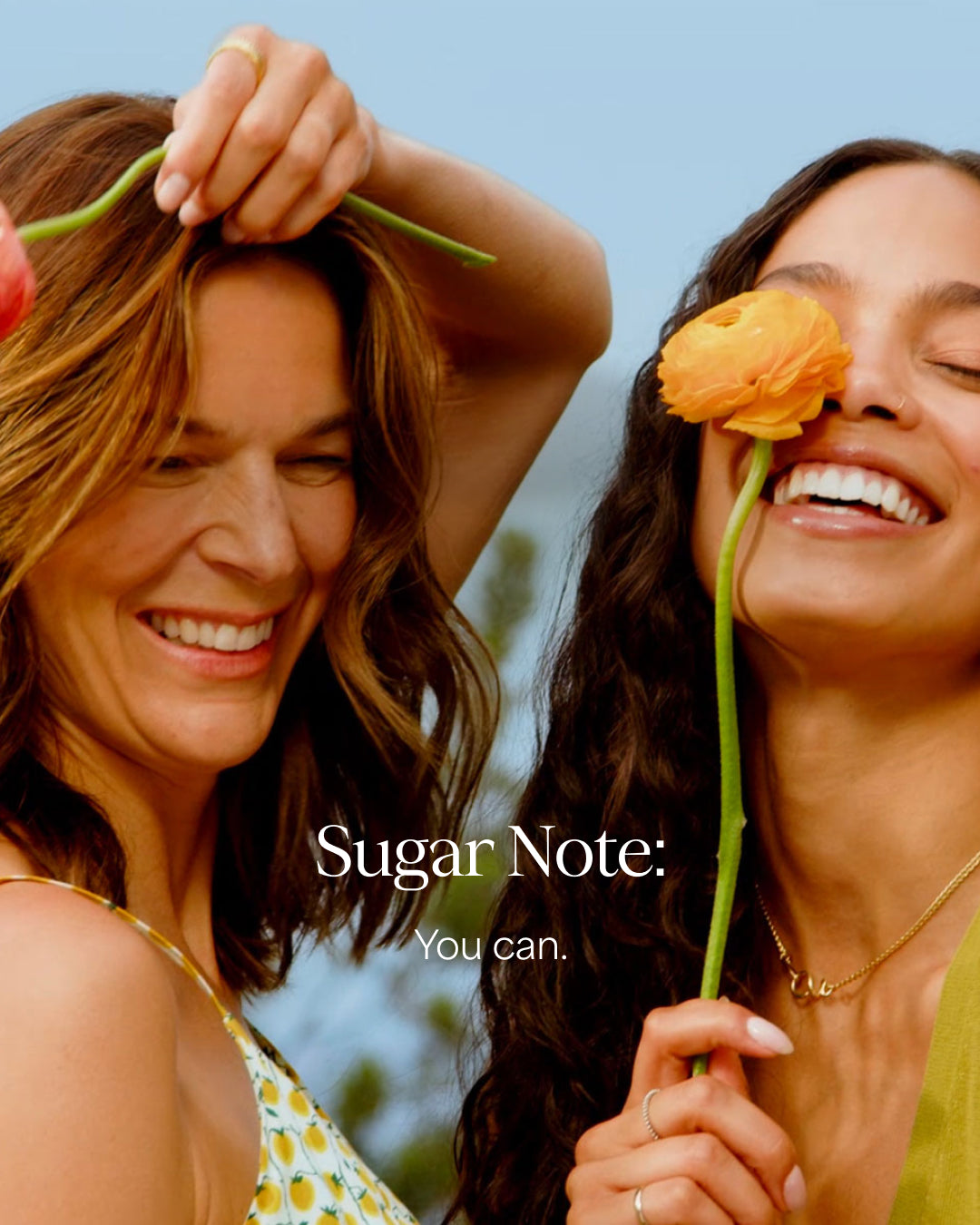 Two women holding flowers with a clear blue sky background and 'Sugar Note' text.