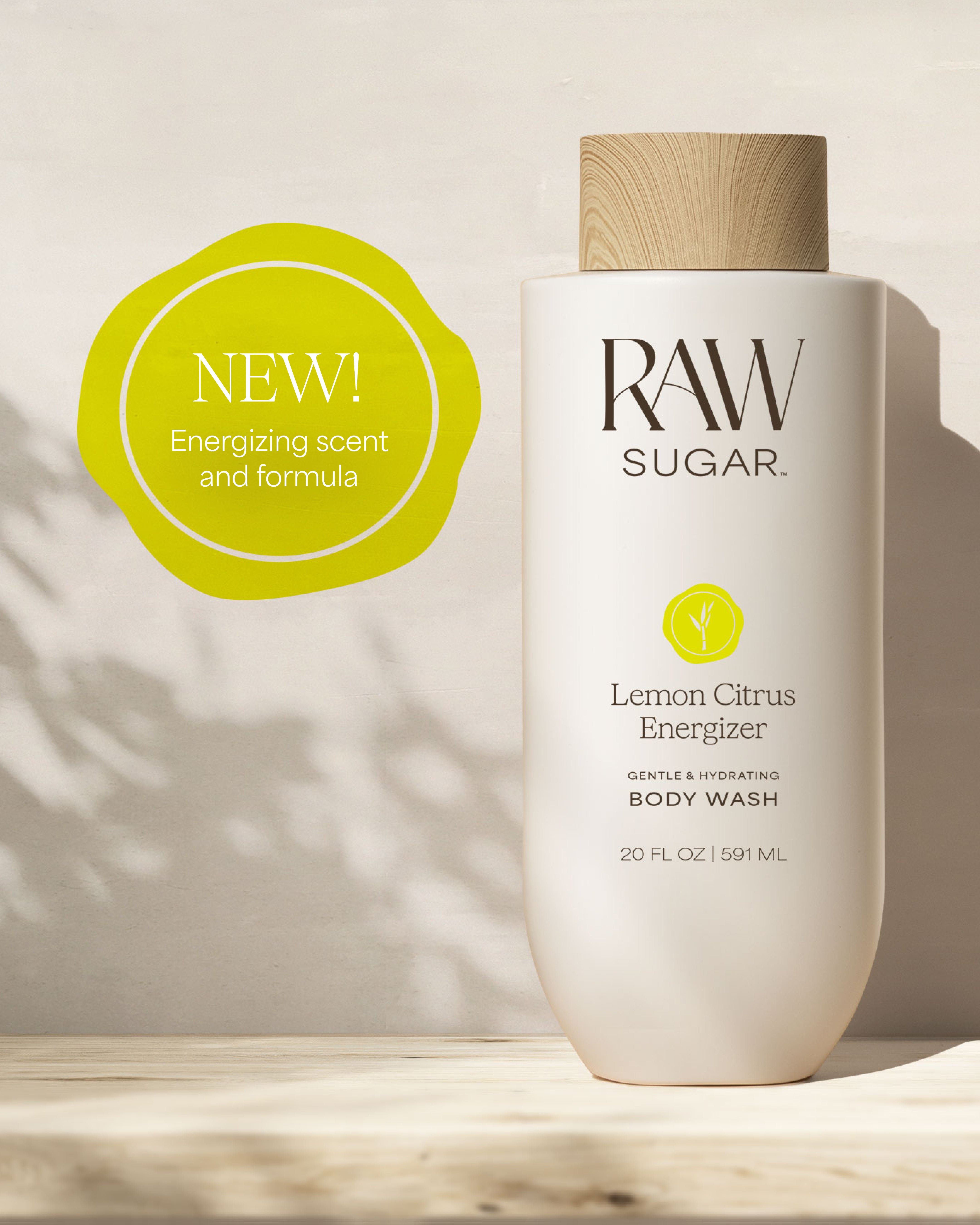 RAW Sugar Lemon Citrus Energizer body wash bottle with a 'NEW!' label on a light background, designed to help gently cleanse and hydrate skin with clean ingredients.