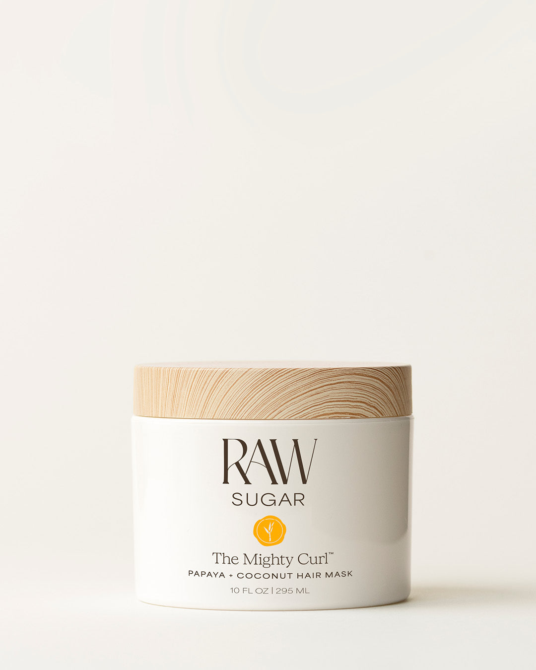 Bottle of Raw Sugar Moisturizing Mask on a cream background, designed to help nourish curly hair with clean ingredients.