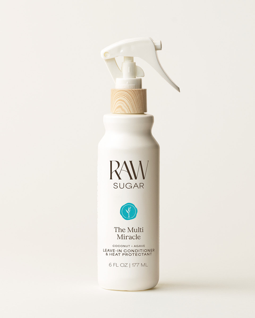 Bottle of Raw Sugar Leave-In Conditioner on a cream background, designed to help protect hair with clean ingredients.