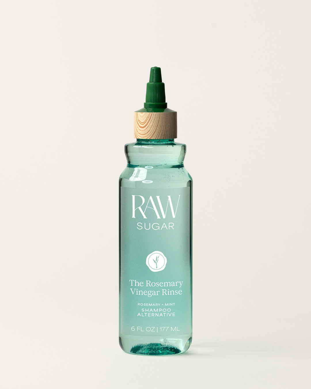 Bottle of Raw Sugar Rosemary Vinegar Shampoo on a cream background, designed to help refresh hair with clean ingredients.