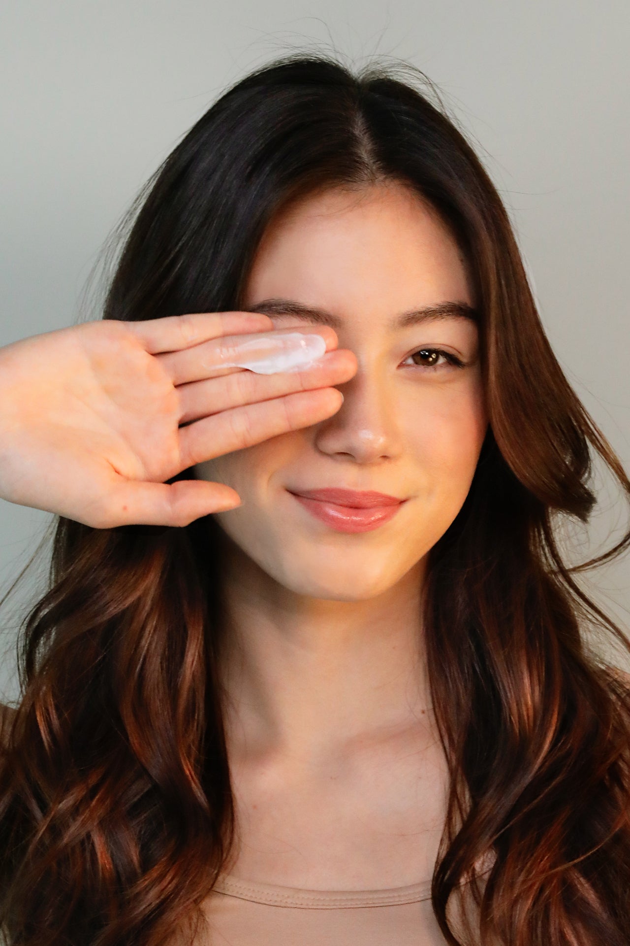 girl with goop of dry shampoo on hand smiling