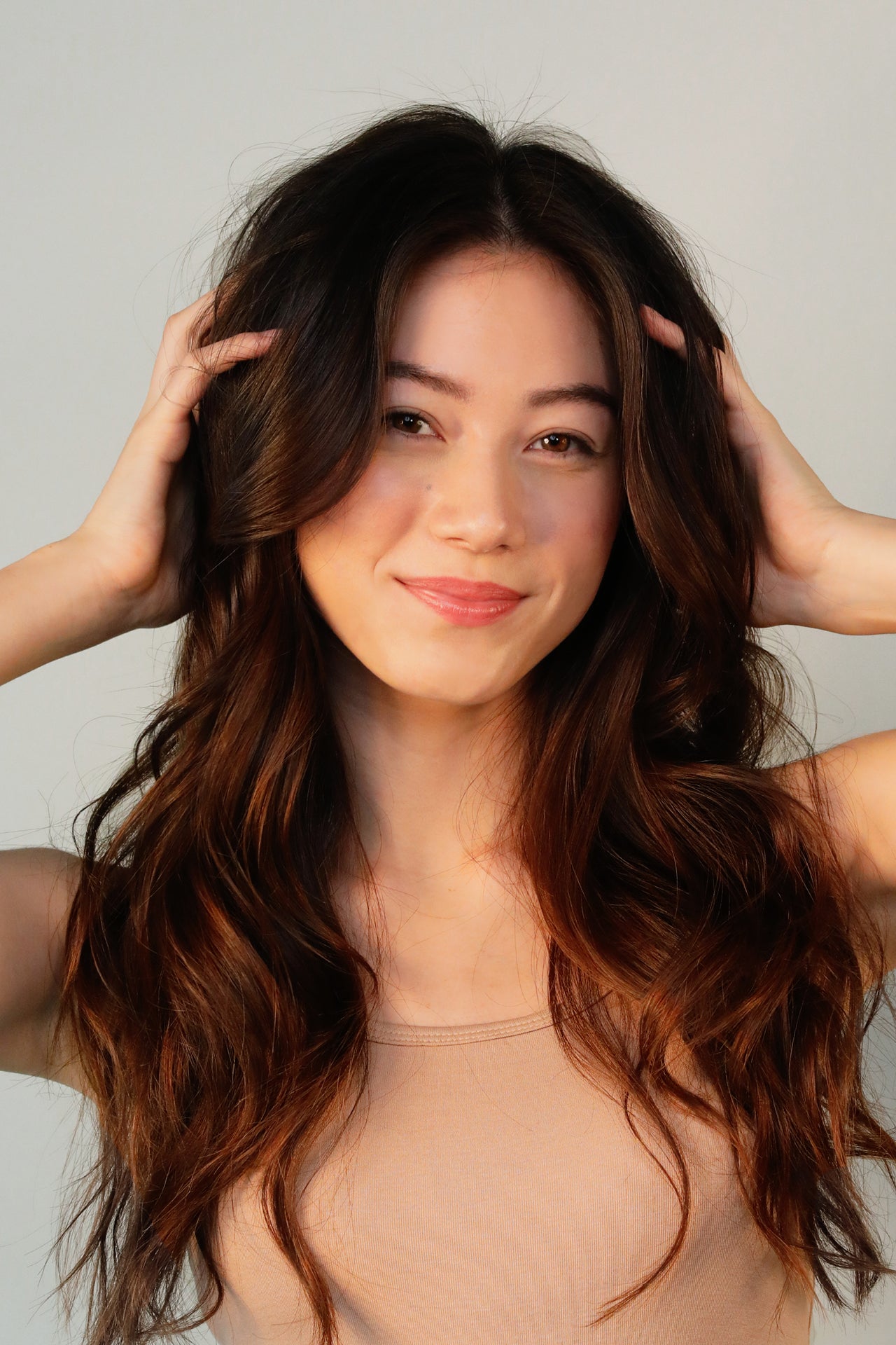woman with hands in hair to put in hair styling product
