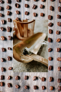 scent image of burning santal in front of rows of coffee beans