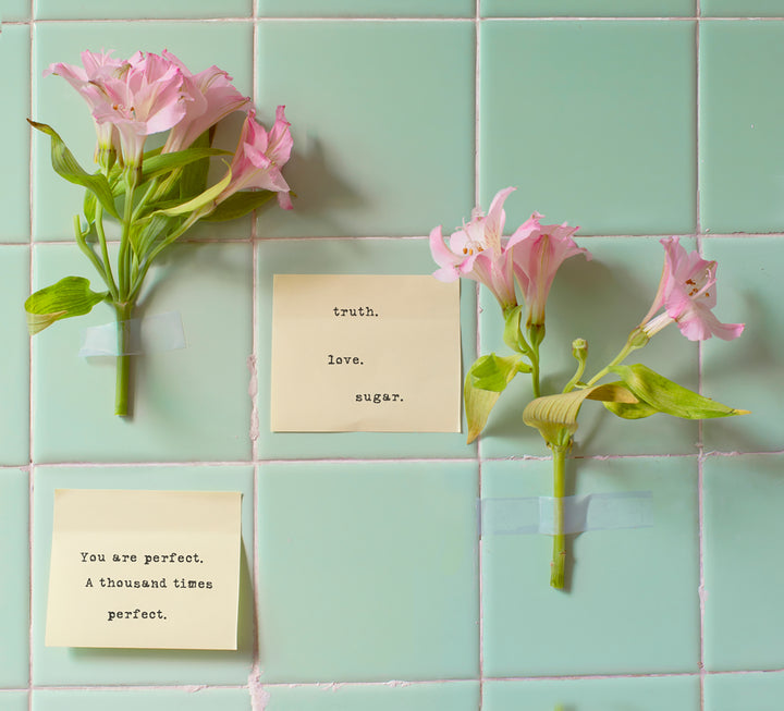 sugar notes on sticky notes on tile next to flowers