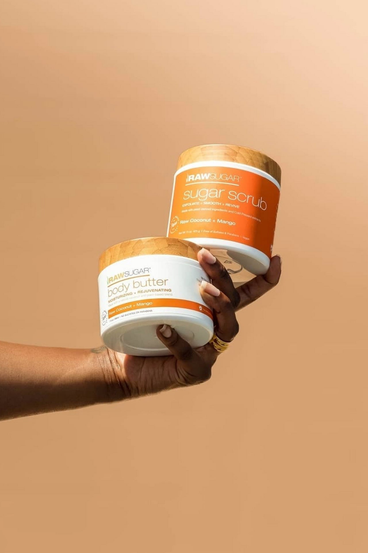 Hand holding Raw Sugar Sugar Scrub and Body Butter