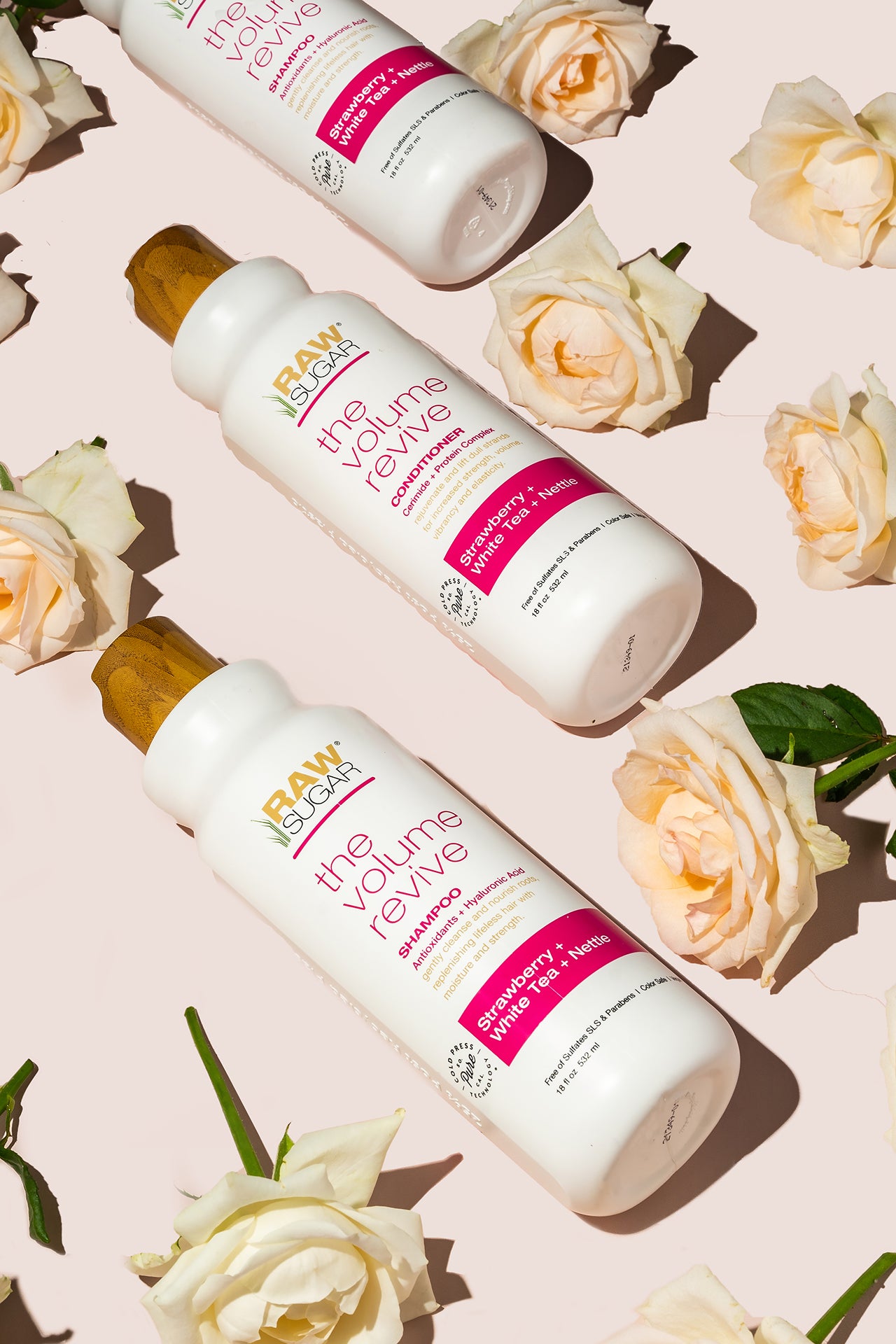 Artful alternating rows of the Volume Revive Shampoo, Conditioner and roses