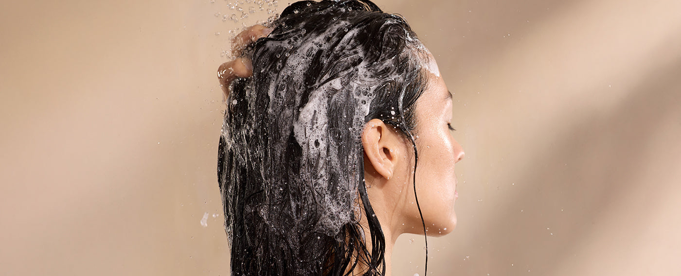 woman shampooing hair with suds on head