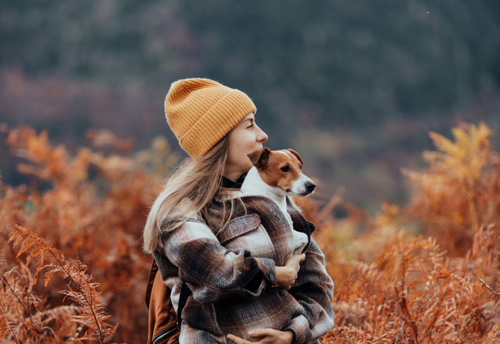 Girl with her dog outside during fall