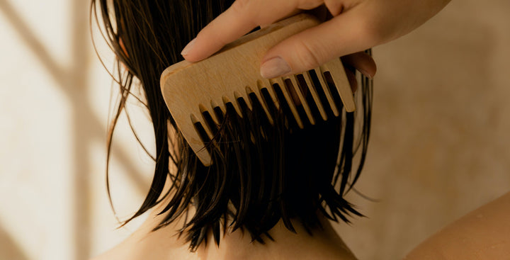 Person Using Comb on Back of Wet Hair