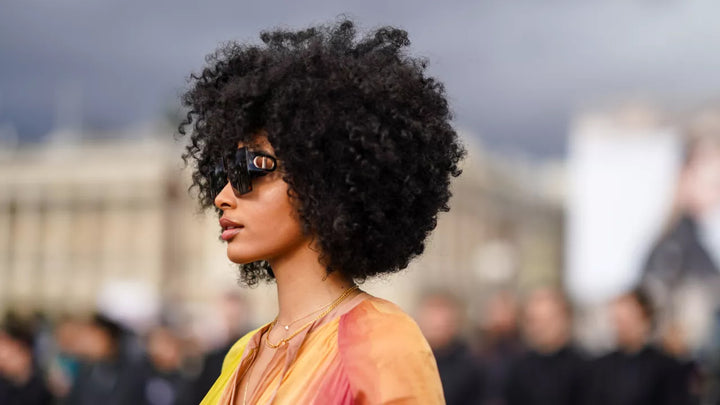 Woman in front of city with afro