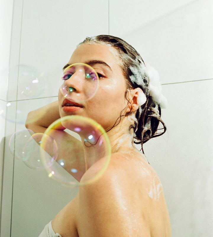 woman in shower with soap and bubbles