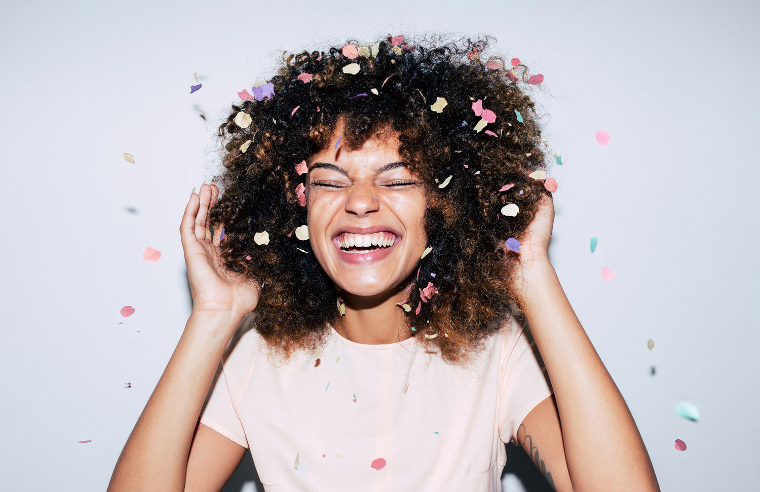 girl with confetti falling in her curly hair