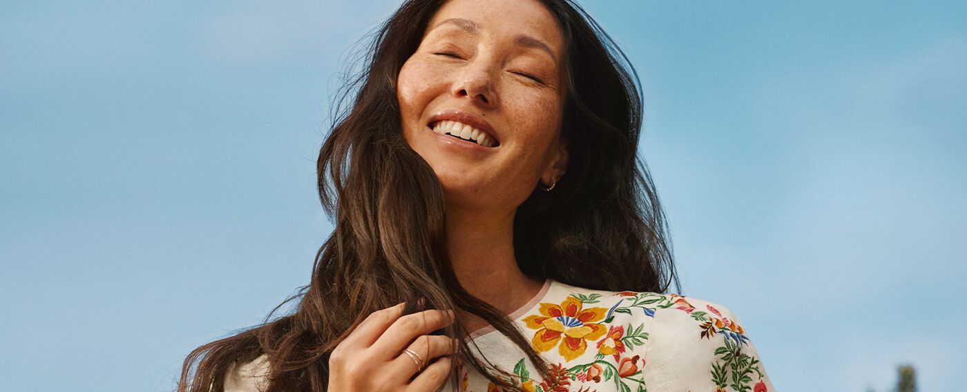 woman smiling against a blue sky background