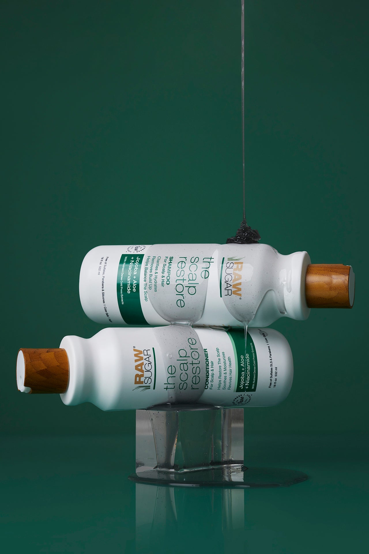 scalp restore bottles sideways in front of green background