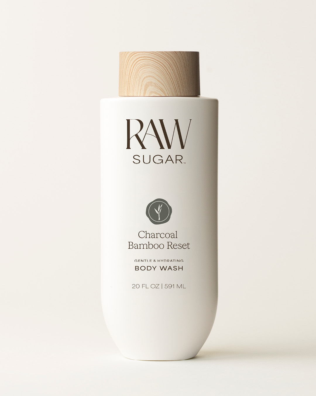 Bottle of Raw Sugar Charcoal Body Wash on a cream background, designed to help gently cleanse and hydrate skin with clean ingredients.