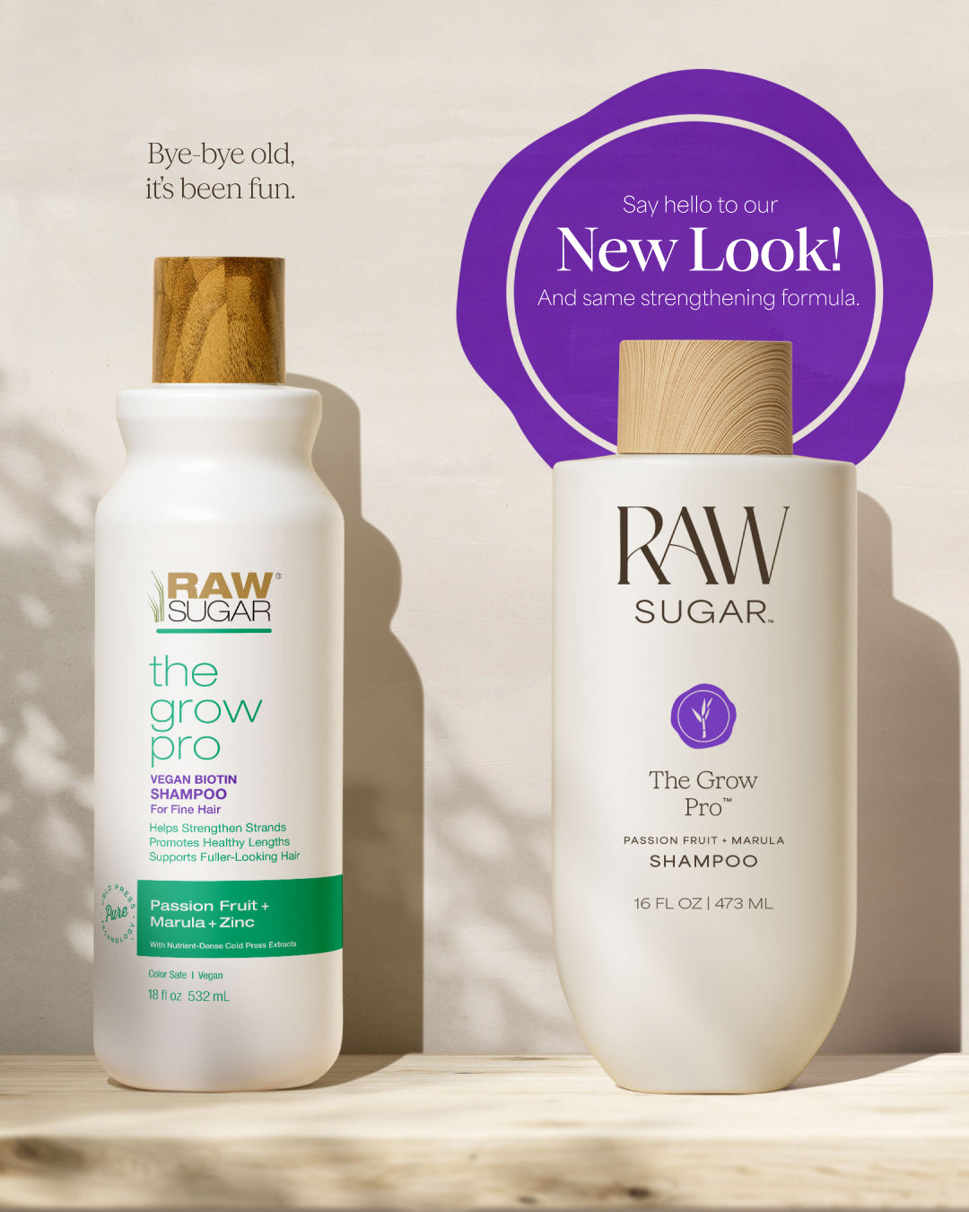 Two bottles of Raw Sugar 'The Grow Pro' shampoo on a wooden surface with a purple circle and text about a new look.