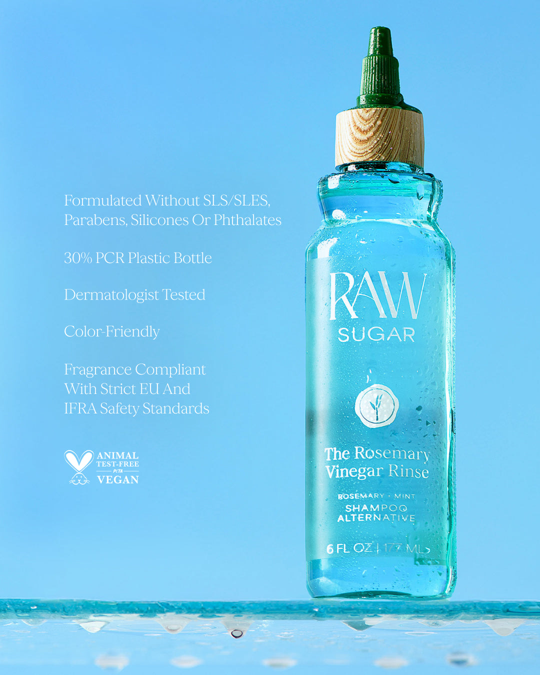 bottle of RAW Sugar Rosemary Vinegar Rinse on a blue background, designed to help refresh hair with clean ingredients.