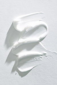 goop image of lotion smeared on white background