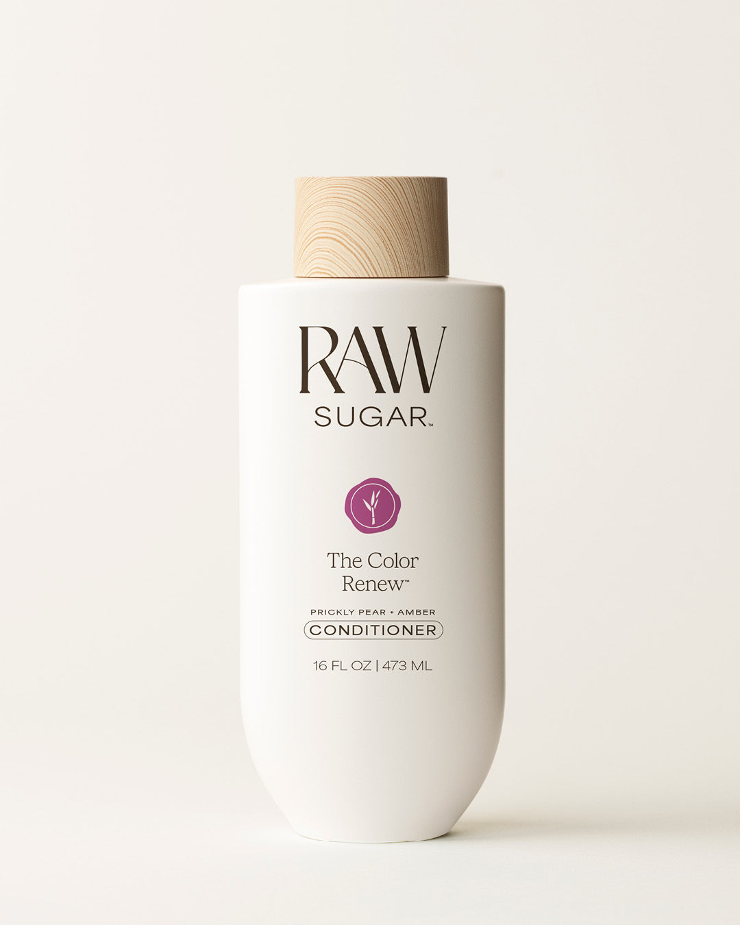 Bottle of Raw Sugar Color Renew Conditioner on a cream background, designed to help protect color-treated hair with clean ingredients.