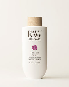 Bottle of Raw Sugar Color Renew Conditioner on a cream background, designed to help protect color-treated hair with clean ingredients.