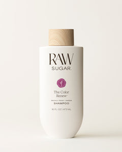 Bottle of Raw Sugar Color Renew Shampoo on a cream background, designed to help color-treated hair with clean ingredients.