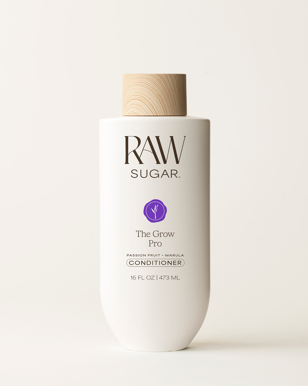 Bottle of Raw Sugar Grow Pro Conditioner on a cream background, designed to help strengthen hair with clean ingredients.