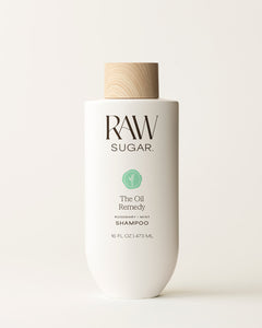 Bottle of Raw Sugar Oil Remedy Shampoo on a cream background, designed to help balance hair with clean ingredients.