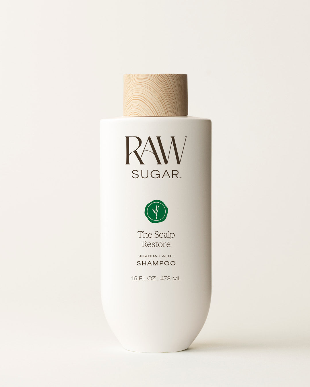 Bottle of Raw Sugar Scalp Restore Shampoo on a cream background, designed to help balance scalp and hair with clean ingredients.
