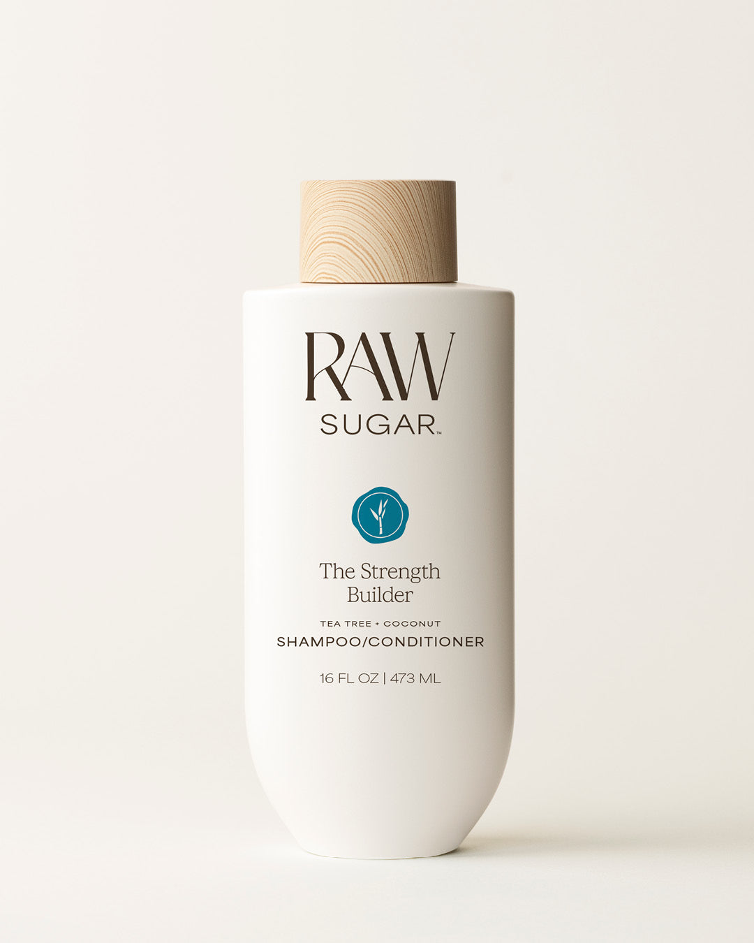 Bottle of Raw Sugar Strength Builder Shampoo on a cream background, designed to help strengthen hair with clean ingredients.