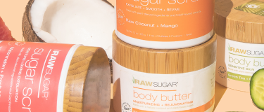 coconut and various body butters and sugar scrubs on orange background