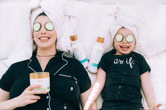 mom and kid laying in bed with cucumber on eyes and hair masque with shampoo and conditioner