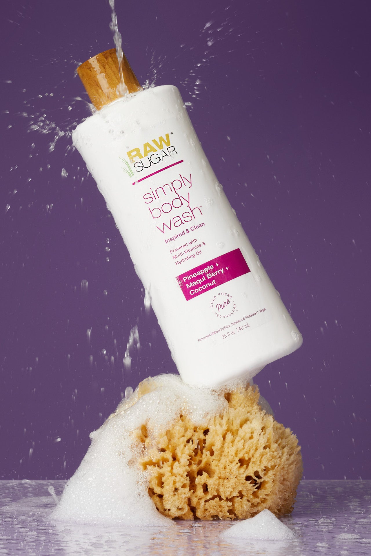 body wash with water pouring on it sitting on loofah