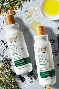 clean good for you scalp restore bottles laying on surface with mix of ingredients